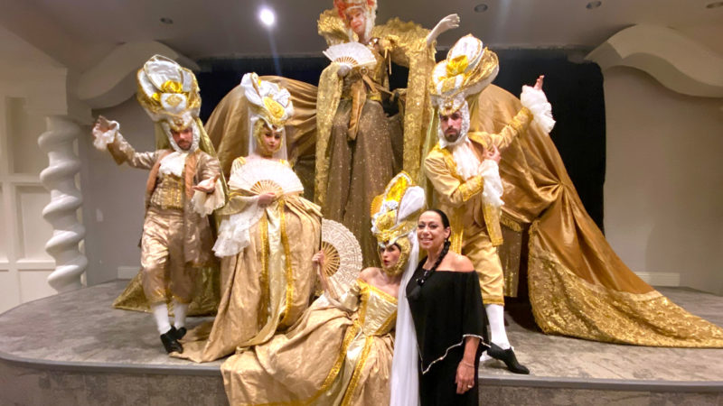 A group of dancers in costumes are posing on a stage.