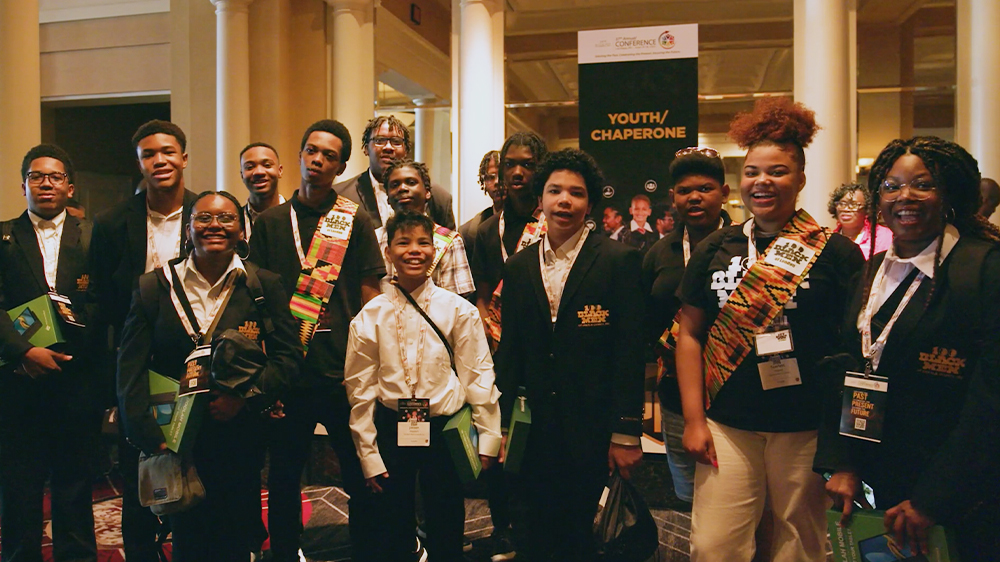 A group of young adults smile and pose for the camera.