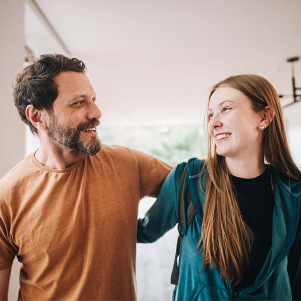 A teenage daughter smiling with her dad